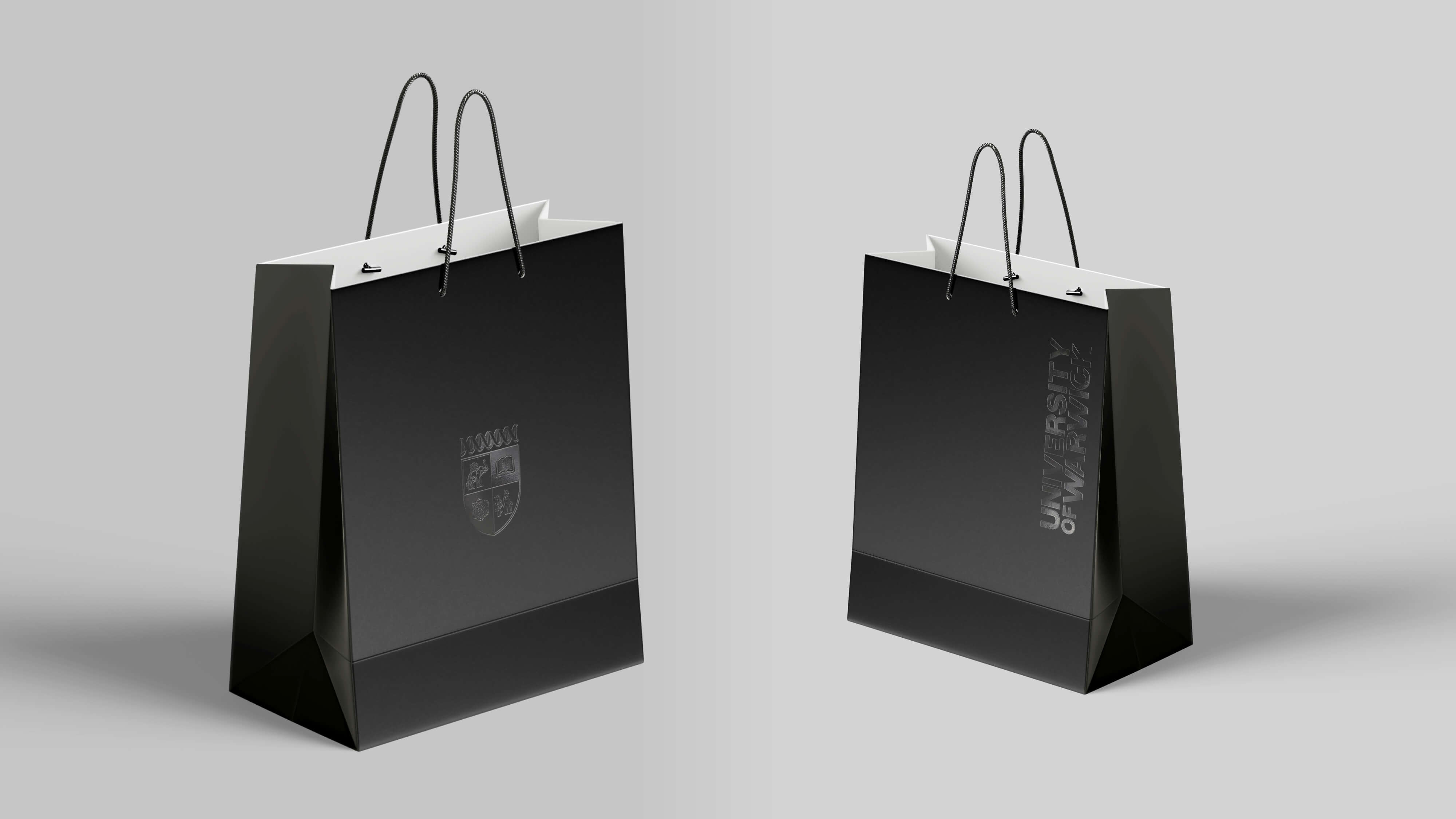 Black paper bags with the University of Warwick Crest. 