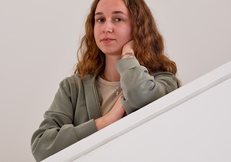 portrait of a student facing the camera while leaning on an angled wall