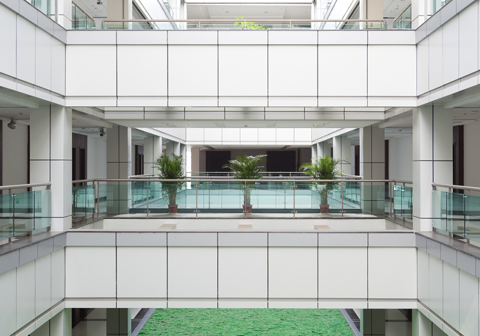 Multiple floors of a white clad building overlooking a central lobby