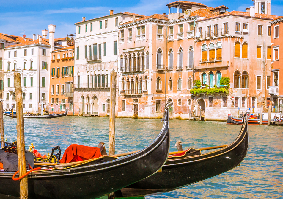 two gondolas moored on the canal in Venice with a view of the buildings behind