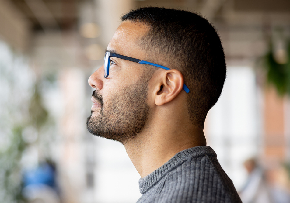 A person wearing blue glasses and facing left