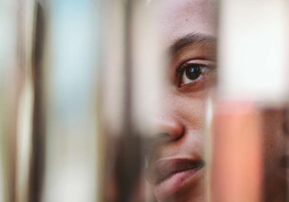 A person's face viewed though, and distorted by, some blurry objects