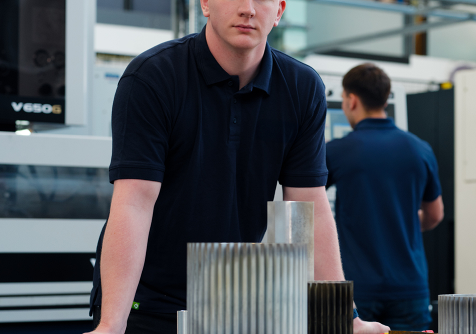 A person stands over some objects, they are shot from an unusual angle and their face is only partially in frame